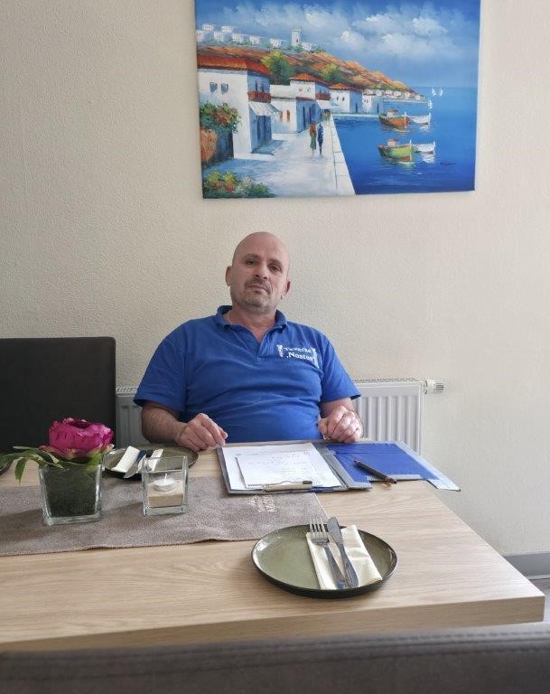 Gastgeber im Gespräch mit einem Paar an einem Tisch